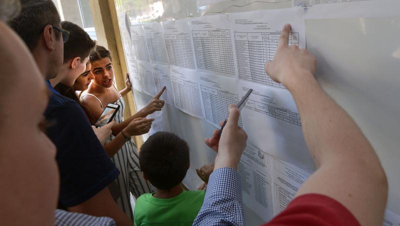 imagine cu elevi privind un tabel cu note la examenul de bacalaureat