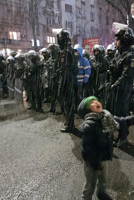 Cea mai puternică imagine de la protestele de aseară! Cordonul de jandarmi și un copil inocent care primește fulgii de nea. Își ridică palmele mici spre cer: "Bucuria e o alegere individuală! Doar dramele sunt colective!"