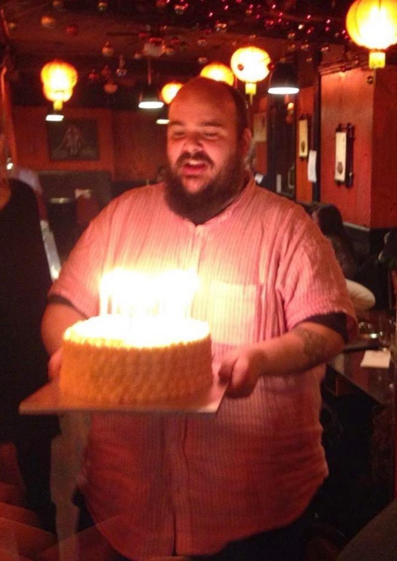 Johnny Bonello ținând un tort aniversar în mâini, pe vremea când avea 190 de kilograme