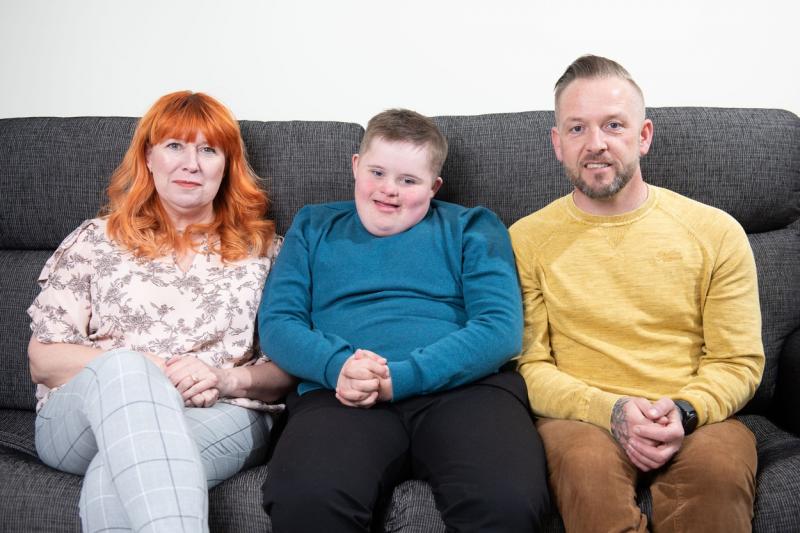 Claire Burke și David, împreună cu fiul lor, stand pe o canapea