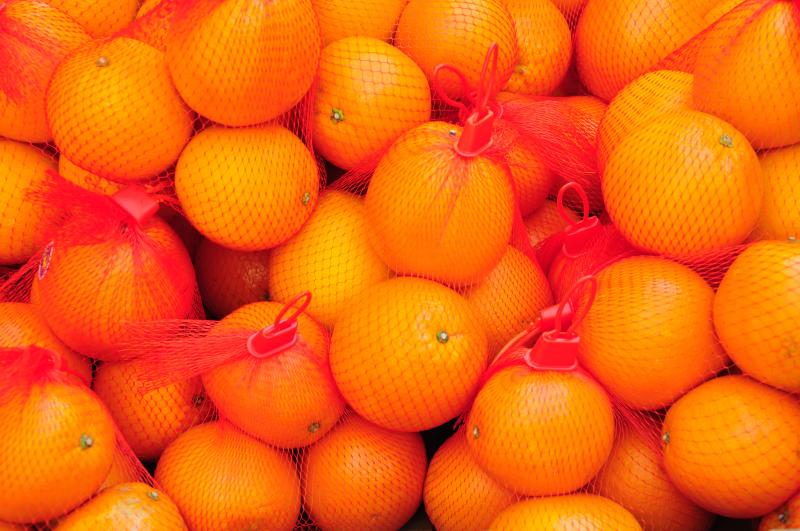 imagine cu portocale înpungi de plasă roșie
