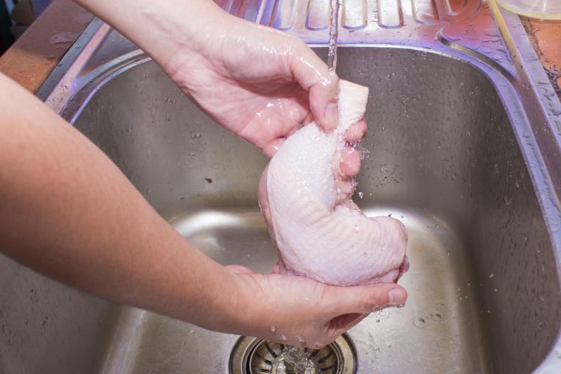 imagine cu mainile unei persoane care spala carnea