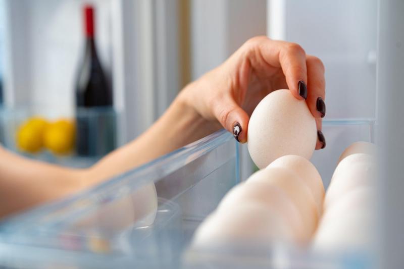 imagine cu mana unei femei care depoziteaza oua in frigider