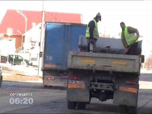 Metoda inedita de asfaltare: Doi muncitori arunca bitum peste gropi, direct din bena unui camion