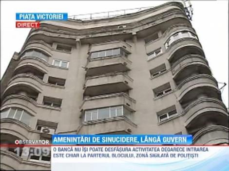 Un barbat s-a urcat pe un bloc din apropierea Guvernului si ameninta ca se sinucide