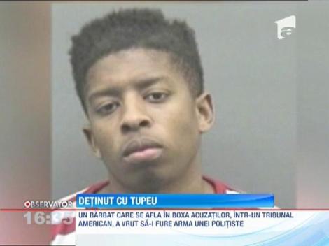 Un detinut care statea in boxa acuzatilor a incercat sa fure arma unei politiste