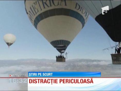 Doi împătimiţi ai sporturilor extreme au încercat să meargă pe sârmă, între două baloane cu aer cald