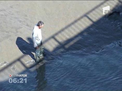 Zeci de oameni au prins peşti cu mâinile goale într-un lac de acumulare secat de autorităţi