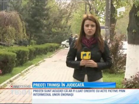 Doi preoţi au fost trimiși în judecată pentru că au încercat să să păcălească 30 de bănci