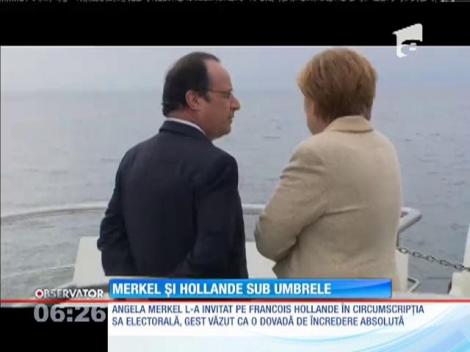 Preşedintele François Hollande şi cancelarul Angela Merkel, sub umbrele