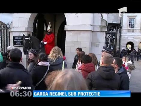 Soldaţii din garda regală, retraşi în spatele unor garduri de protecție