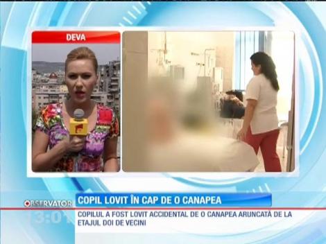Copil lovit în cap de o canapea