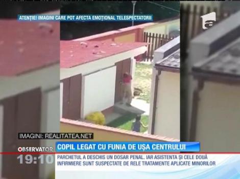 Copil legat cu funia de uşa centrului de plasament