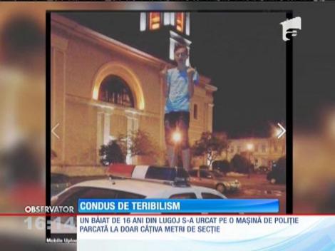 Și-a făcut o fotografie căţărat pe o maşină de poliţie, iar acum este dat în urmărire