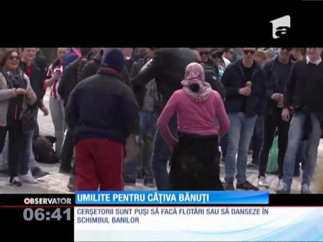 Cerşetori români umiliţi în Madrid. Au fost puşi să facă flotări sau să danseze în schimbul banilor