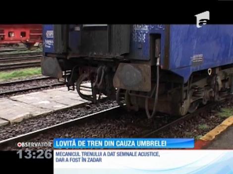 O tânără de 22 de ani a fost lovită de tren din cauza umbrelei