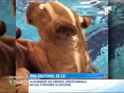 Un bărbat sărută un pui de leu