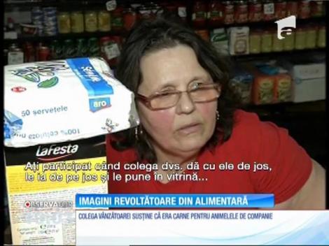 O vânzătoare încearcă să desfacă bucăţi de carne congelată dând cu ele de pământ