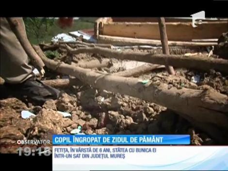 Copil îngropat de un perete de pământ