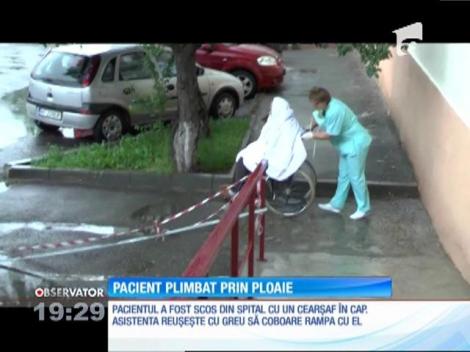 Imagini şocante la cel mai mare spital din judeţul Neamţ. Un pacient în vârstă este transportat cu căruciorul, prin ploaie, de o infirmieră