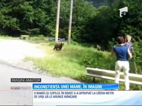 O mamă cu copilul în brațe s-a apropiat de urși să le arunce mâncare