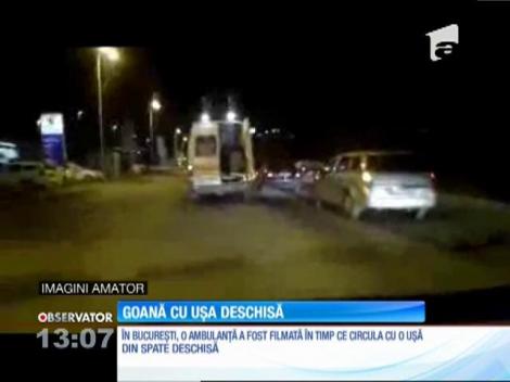 O ambulanţă a fost filmată în traficul din Bucureşti cu girofarele pornite şi cu uşa larg deschisă în spate