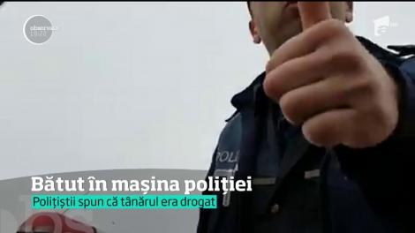 Scene şocante au fost surprinse în România! Un om al străzii, jucat în picioare într-o maşină de Poliţie!