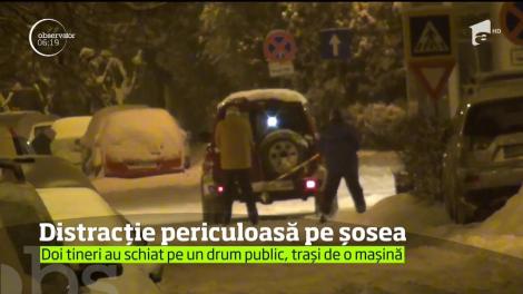 Doi tineri din Baia Mare au ales să practice schiatul pe şosea, traşi de un autoturism