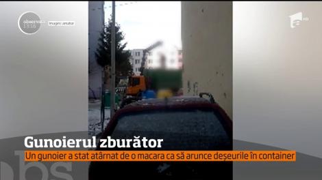 Un gunoier a stat atârnat de o macara ca să arunce deşeurile în container