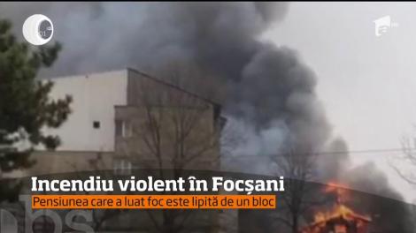 Incendiu puternic, într-un cartier din Focşani! O pensiune din lemn, lipită de un bloc şi foarte aproape de o benzinărie, a luat foc