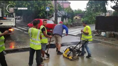 Imagini revoltătoare au fost surprinse la Iaşi, unde o echipă de muncitori a turnat asfalt, ca să aibă ce lua ploaia