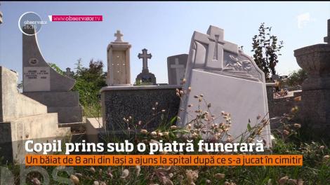 Copil prins sub o piatră funerară, într-un cimitir din Iași