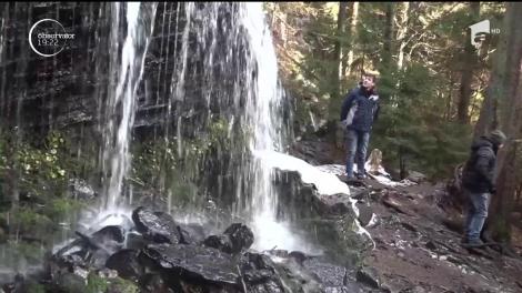 În inima unei păduri din Harghita, frumuseţea unei cascade atrage iarna tot mai mulţi turişti