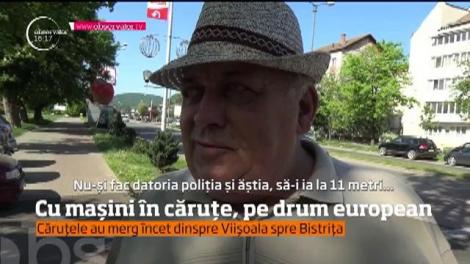 Cu mașini în căruțe, pe un drum european din Bistriţa