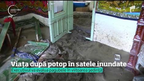 Viața după potop în satele inundate. Nămolul acoperă uliţele şi casele