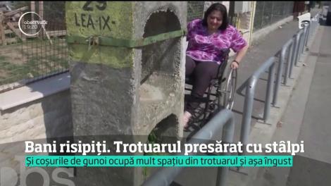 Un trotuar din Timişoara lat de niciun metru e presărat cu stâlpi. Un om în cărucior cu rotile fie merge pe şosea, printre maşini, fie face cale-ntoarsă
