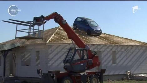 Un român din Arad a urcat o maşină pe un acoperiş să-şi convingă clienţii cât de trainice sunt