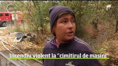 Sunt aproape 24 de ore de când un incendiu violent mistuieşte un depozit de maşini vechi din Craiova