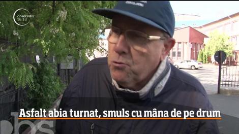 Asfalt abia turnat, smuls cu mâna de pe un drum din Vatra Dornei