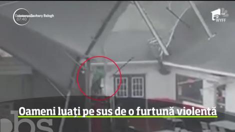 Imagini incredibile din Statele Unite! Vântul foarte puternic a luat pur şi simplu pe sus doi oameni, pe terasa unui restaurant