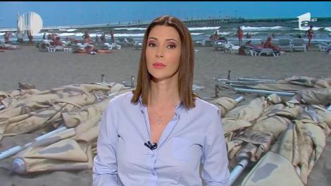 Turiştii care au venit la mare la sfârşitul sezonzului estival se bronzează printre remorci