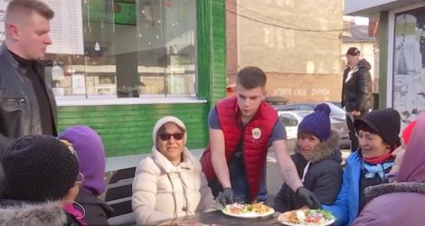 "Tanti, ia un hamburger din partea noastră!" Doi tineri din Târgu Jiu ajută oamenii nevoiaşi cu o masă caldă