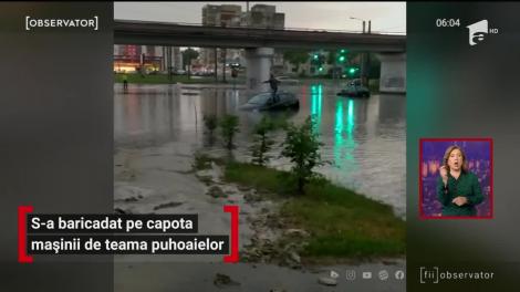 Furtuna a făcut prăpăd! Un bărbat s-a baricadat pe capota mașinii de teama puhoaielor. Imagini virale în România - VIDEO