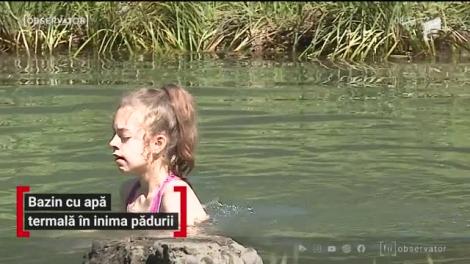 Bazin cu apă termală în inima pădurii