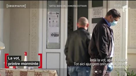 Şi la slujbă şi la urne. Ambele cam în acelaşi timp. Asta s-a întâmplat într-o comună din Iaşi, unde secţia de votare a fost amenajată într-un cimitir