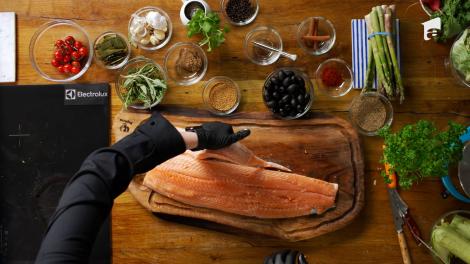 Roxana Blenche și Mihail Pautov pregătesc somonul pentru un preparat delicios