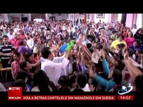 Metodă inedită de aduce copiii la biserică! Un preot din Mexic are o robă cu personaje din desene animate şi îi stropeşte pe cei mici cu apă sfinţită cu un pistol