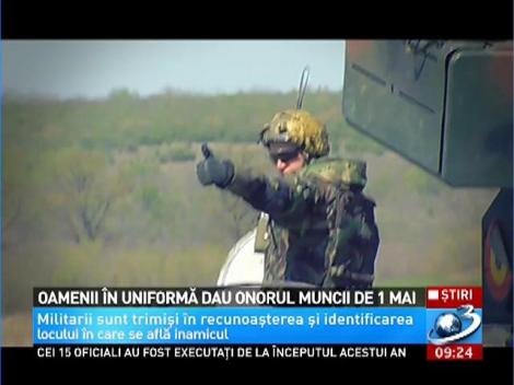 Oamenii în uniformă dau onorul muncii de 1 Mai