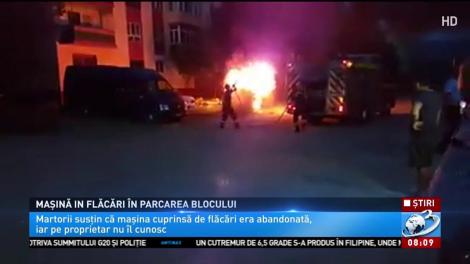 Mașină în flăcări în parcarea blocului
