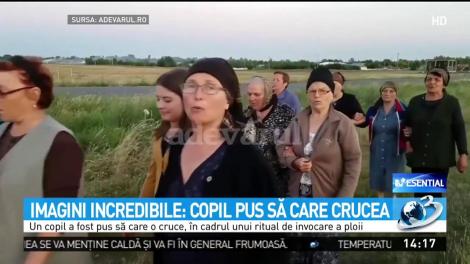 Imagini șocante &icirc;n Rom&acirc;nia! Un copil, plimbat cu o cruce de lemn kilometri &icirc;ntregi